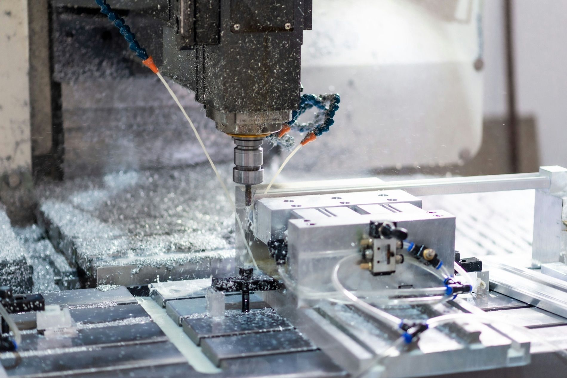 A milling head cutting an aluminium part under coolant