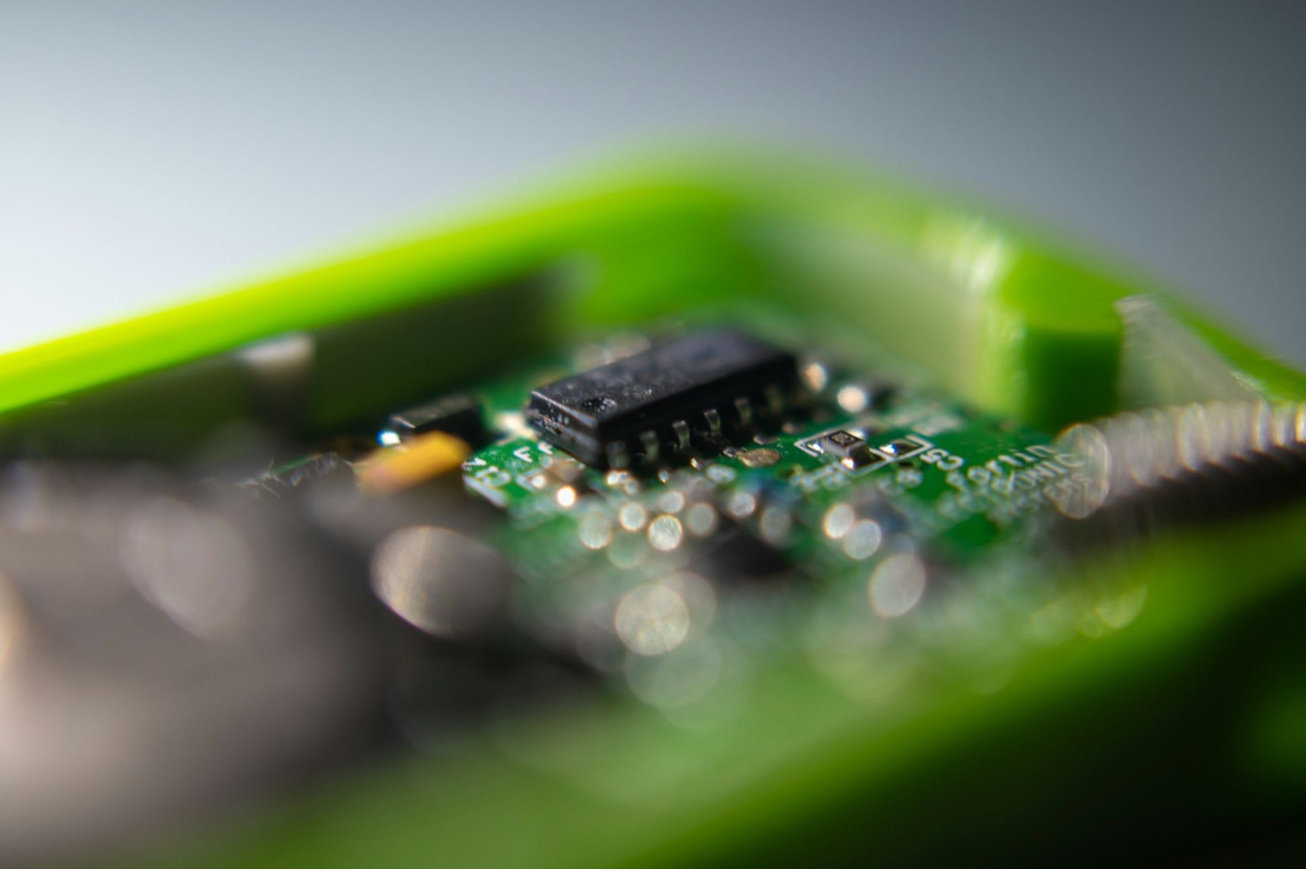 A circuit board at close range, one chip in focus and the rest of the board falling away.