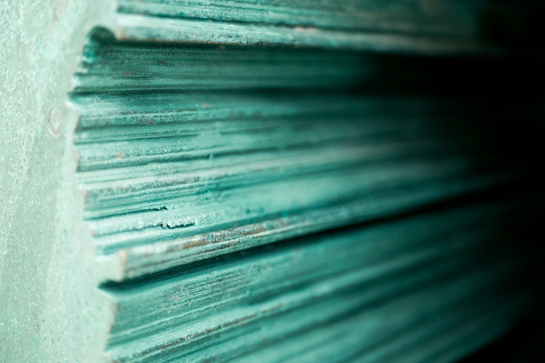 The cut edges of stacked metal sheets, each leaf a separate bright line.