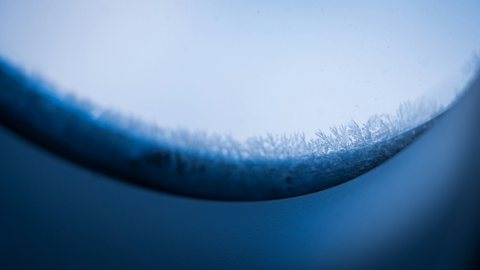 The cutting edge of a blade at high magnification, the ground bevel breaking into a fine burr along the top.