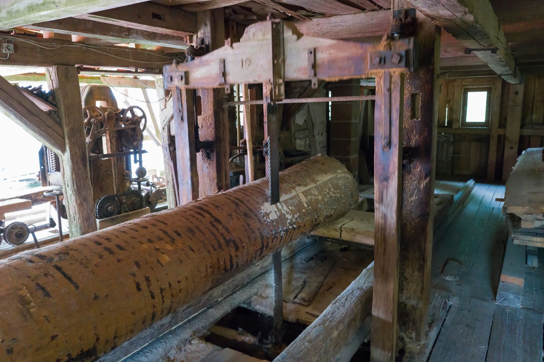 A log carried through an old sawmill on its rails