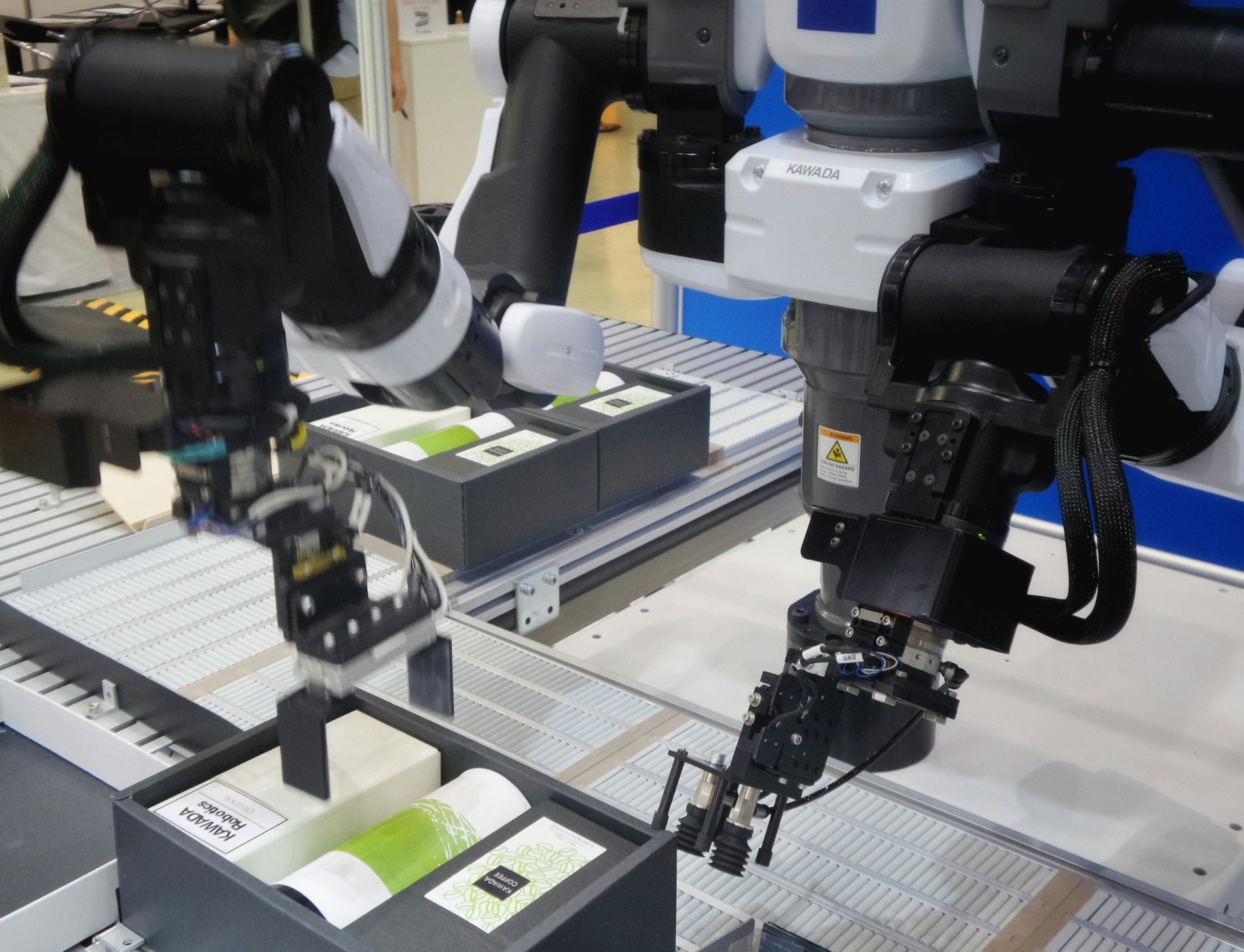 A robot arm lifting a printed sheet off a line