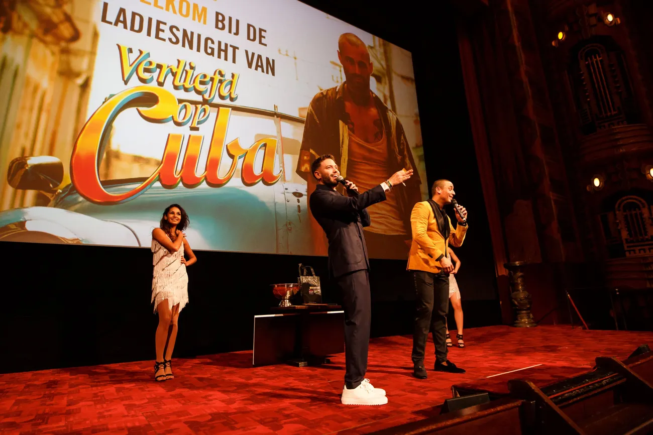 Ladies Night event on stage in front of the cinema screen, with hosts and dancers